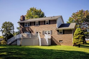 Expansive side yard with lush greenery and easy access to a stunning deck overlooking serene landscapes.

