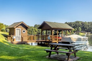 A picturesque private boathouse complete with a dock and seating, offering direct access to tranquil waters.