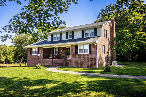 A charming brick home with a cozy front porch, perfect for sipping your morning coffee while enjoying the peaceful surroundings.
