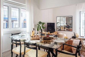 Santa Marta dining room with a glass table and woven chairs, showcasing a light and airy aesthetic.