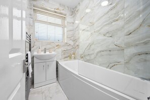 A luxurious bathroom designed for comfort and relaxation, featuring elegant finishes and modern amenities. Enjoy a refreshing shower with complimentary soap, shower gel, and shampoo ensuring a stress-free stay.