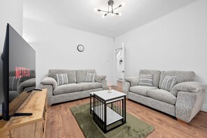 A cozy and inviting living area featuring a 55-inch VIDAA Smart TV, perfect for relaxing and enjoying your favorite shows. Sink into two comfortable couches and unwind in style.