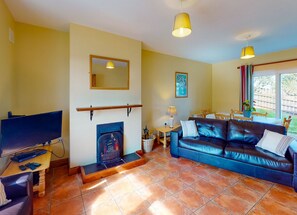 Dunmore East, County Waterford, Ireland. Dining table, open plan living room. Open Fire.