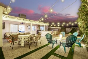 Enjoy the ultimate backyard retreat with a hot tub, corn hole, covered patio, BBQ, and fire pit for endless relaxation and fun.