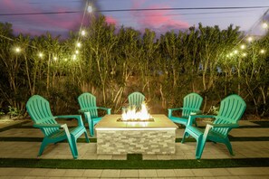 Enjoy the ultimate backyard retreat with a hot tub, corn hole, covered patio, BBQ, and fire pit for endless relaxation and fun.