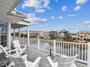Experience serene waterfront living on this expansive deck, perfect for soaking up the sun, with scenic canal views and luxury beach house features.