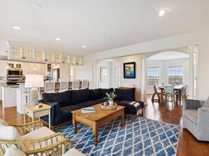 This elegantly designed living space features vaulted ceilings and abundant natural light, perfectly situated for ocean views, making it an ideal setting for relaxation and entertainment.