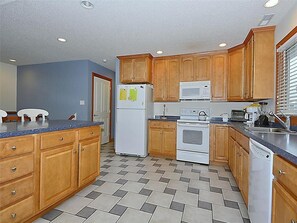 Fully equipped kitchen featuring ample counter space, wooden cabinetry, and modern appliances for family cooking.