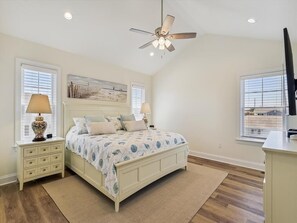 Spacious bedroom with coastal-inspired decor and natural light, offering a serene space for rest and relaxation.