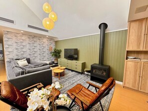 Cozy living space with high ceiling and fireplace