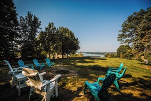 Bright and colorful chairs on a well-maintained lawn, offering a perfect spot for lakeside relaxation.