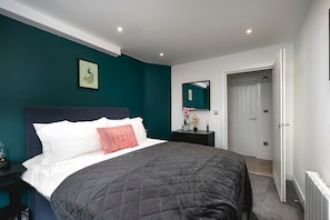 Bedroom with bold green wall and cozy bed