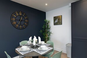 Dining nook with bold clock and plant decor