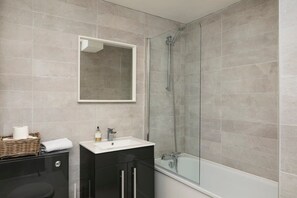 Contemporary bathroom with sleek tiles and glass shower screen