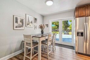 Elegant dining space in Clearwater with pool views, perfect for group brunches or family dinners, featuring modern artwork and bring natural light. 