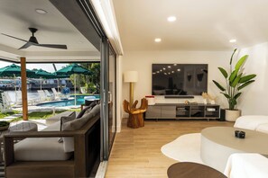 Expansive glass doors offer stunning poolside and canal views.