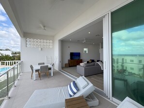 Balcony includes dining table, loungers, and drying racks.