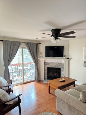 Living Room w/ Couch, Two Oversized Faux Leather Chairs, and a 50-inch Smart TV with Roku. 