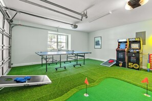 Garage features a putting green area, arcade games, cornhole and a ping pong table.