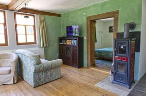 Wohnzimmer mit Ofen und TV