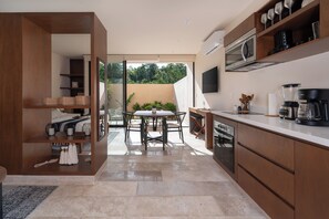 A bright dining area with large windows that let in natural light and garden views.