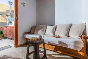The top floor of Casa Eleni features a versatile sofa that converts into a double bed, a full bathroom for convenience, and direct access to the roof terrace, creating a cozy and functional space.