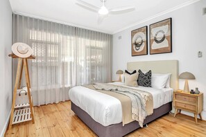 The thoughtfully furnished primary bedroom offers a queen-size bed, side tables with reading lamps and space to hang your belongings.