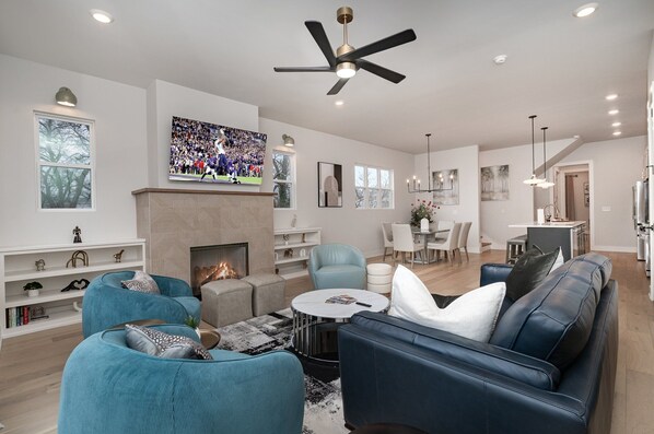 Bright open floor 2nd living space featuring a smart flat-screen TV, gas fireplace, and designer furnishings. (2nd Floor)