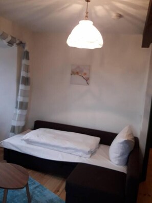 Zimmer mit Sofa oder mit einem Bettder ausgezogen mit Doppelbett