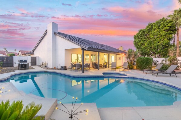 Backyard view showcasing the pool, hot tub, and outdoor lounge areas.