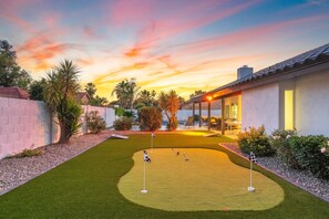 Practice your short game on the putting green with stunning sunset views.