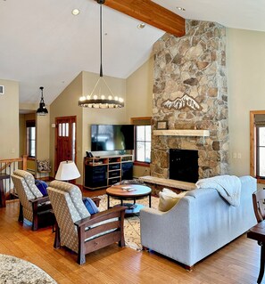 Cozy living room with gas fireplace, TV, and views of the mountains