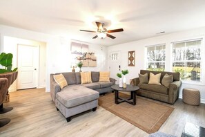Living room with comfortable couches, sleeping couch, office table, fireplace and smart TV