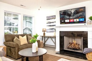 Living room with comfortable couches, sleeping couch, office table, fireplace and smart TV
