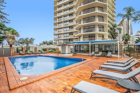 Relax by the sparkling shared pool, complete with sun loungers and lush landscaping, perfect for soaking up the Surfers Paradise sunshine.