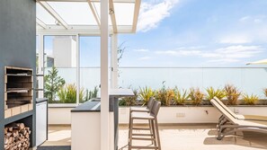 Host memorable BBQs on the private terrace of SkyView Penthouse by LovelyStay, with ample space to grill, enjoy cold drinks, and take in stunning city, ocean, and mountain views. #barbecue