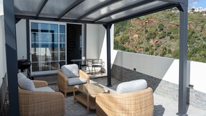 Cozy up in the inviting lounge area at Ozeanica Heights by LovelyStay, featuring stylish decor and comfort under the pergola. #patio #modern