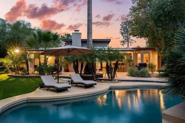 A Tranquil Backyard Oasis, Adorned with Lushes Palms and Cozy Seating for the Whole Group!