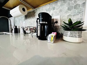 coffee station with a variety of supplies, set against a beautiful hexagonal backsplash for a stylish start to your day.