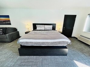 A bright and inviting room with a comfortable bed, soft linens, and ample natural light for a restful experience.