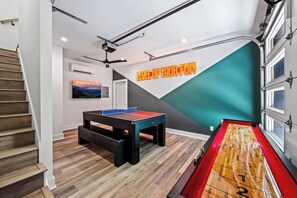 Experience ultimate relaxation in our modern entertainment room, complete with a sleek pool table and cozy seating.