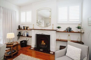 On the side of the lounge, a cosy fireplace adds warmth and charm, complemented by elegant display pieces for a touch of sophistication.