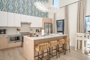 Sleek and modern, this kitchen shines with stainless steel appliances and a spacious island with bar seating for four.