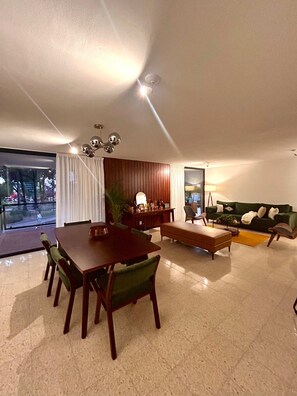 Dining area  with access to the balcony and panoramic view of a park.
