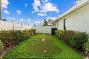 Enjoy a serene day in this beautifully maintained backyard, featuring a charming putting green and vibrant landscaping, perfect for relaxation and leisure!