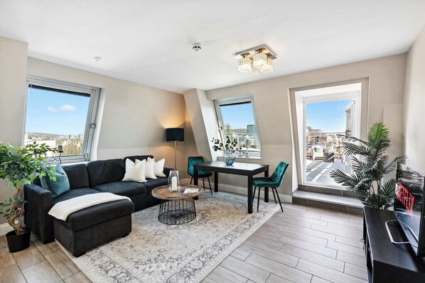 Elegant penthouse lounge with rooftop access, plush seating, and skyline views. Perfect for sunset drinks or a Netflix night in Brighton.