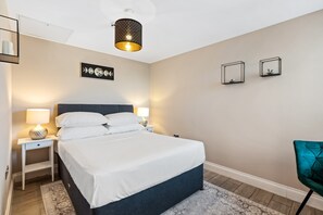 Peaceful bedroom with a plush double bed, soft lighting, and modern decor. Perfect for a restful Brighton retreat.