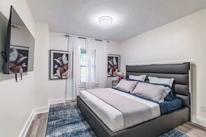 St Pete rental king bedroom with wall-mounted TV and luxury bedding 