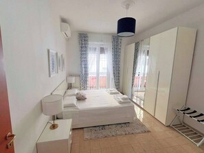 Master bedroom, with large wardrobe, cabinet with drawers, floor lamp, TV.