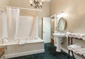 Bathroom with a Jacuzzi tub and elegant chandelier lighting
